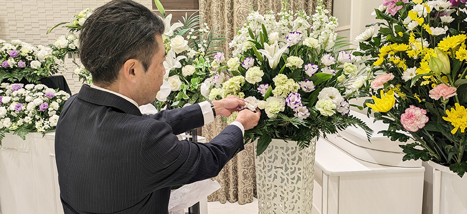 家族葬の広仏葬儀スタッフが葬式祭壇の生花を整えている様子